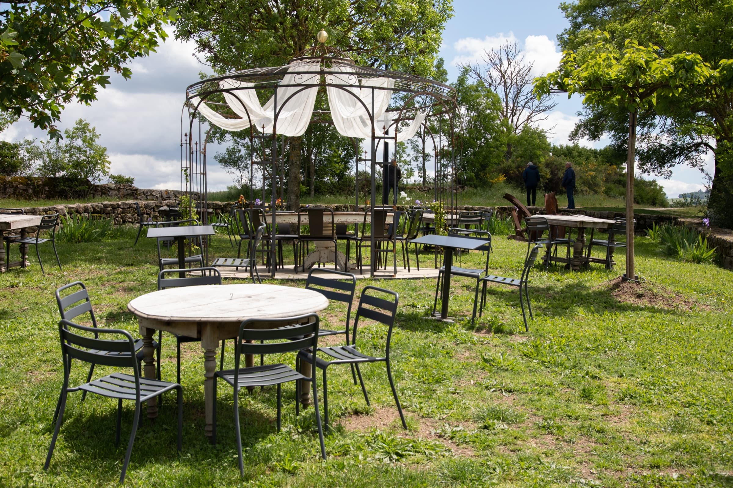La terrasse-jardin extérieure d'Ess'Folie avec tables et chaises
